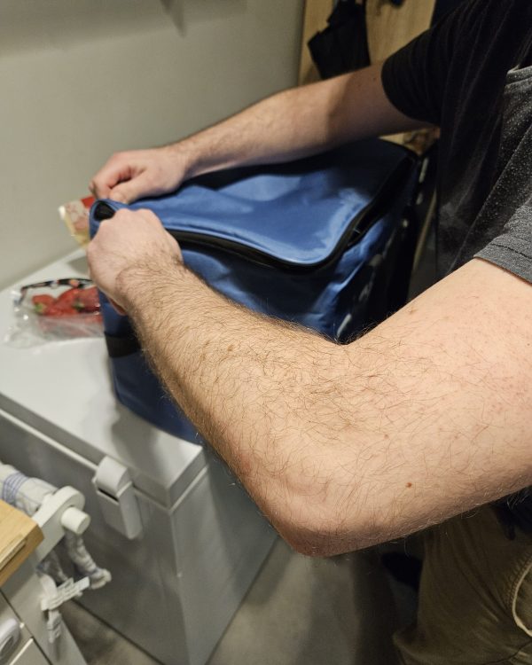 Étienne prépare un sac isotherme avant une intervention à domicile